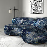 Sofa in printed velvet fabric with painterly-style skyscape design in blue colours.