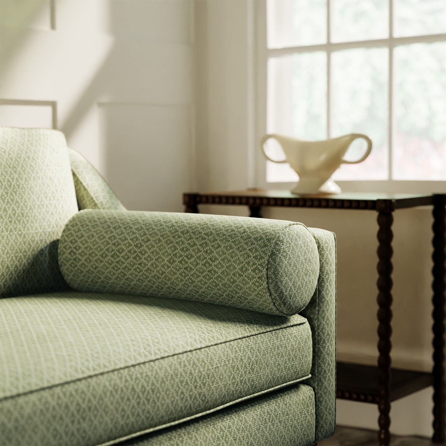 Sofa upholstered in a green and neutral printed linen fabric with a geometric pattern