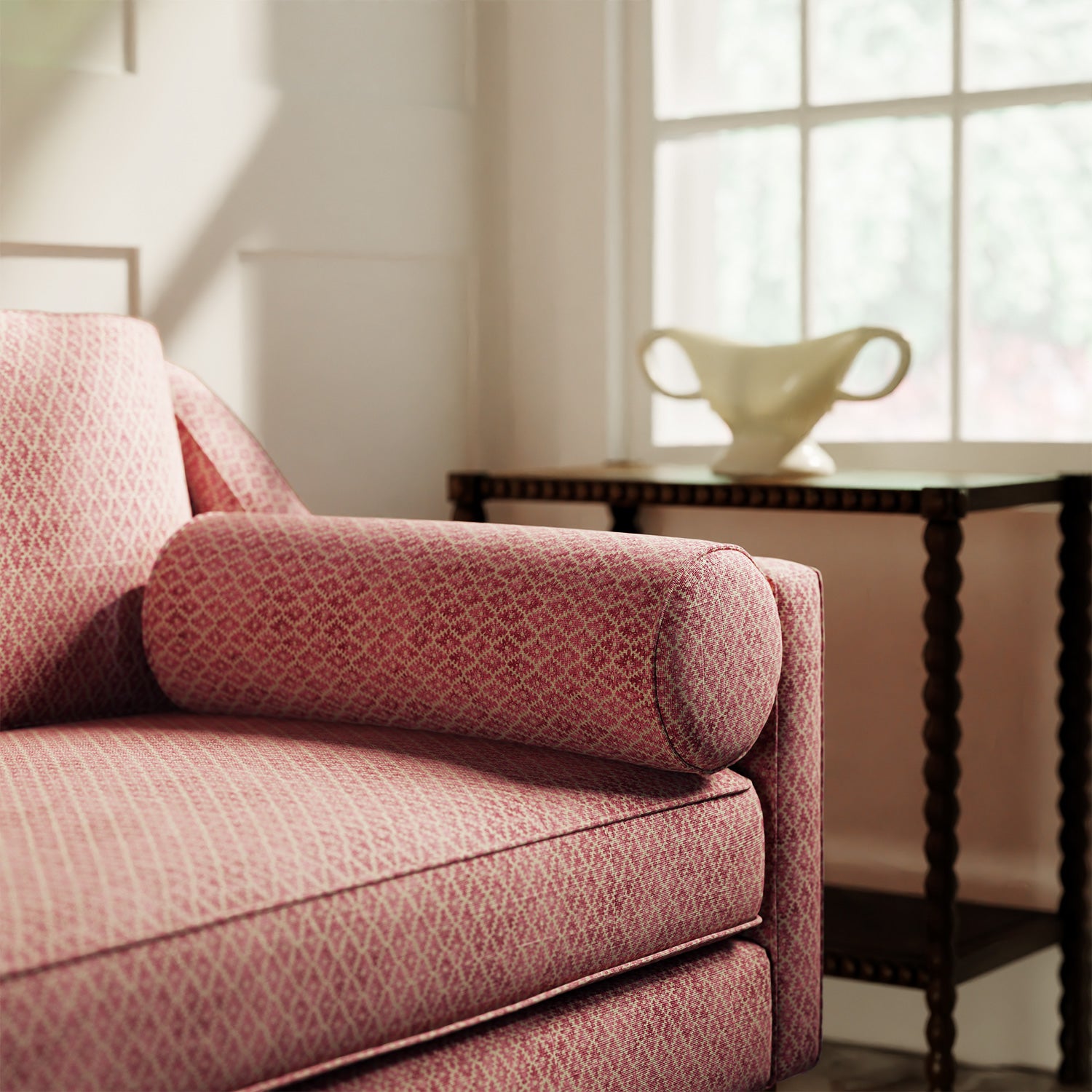 Sofa upholstered in a red and neutral printed linen fabric with a geometric pattern