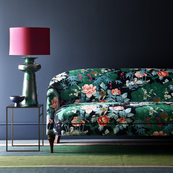 Sofa upholstered in an aqua coloured velvet upholstery fabric with a floral and bird design with a stain resistant finish.